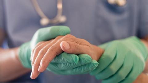 Anaesthetist or anaesthesiologist holding patient's hand