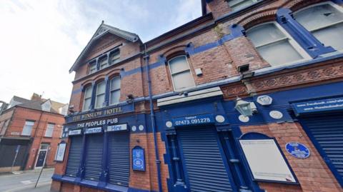 The Winslow Hotel, which has its signage, shutters and some brickwork painted in royal blue and has an additional sign stating 'The People's Pub'