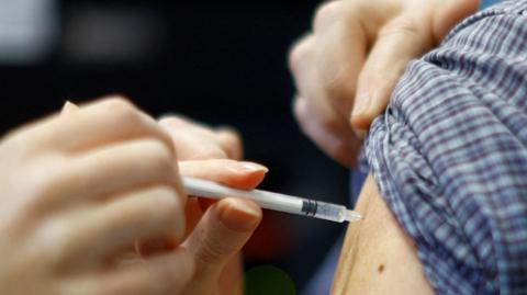 A close up of someone being vaccinated in the arm.