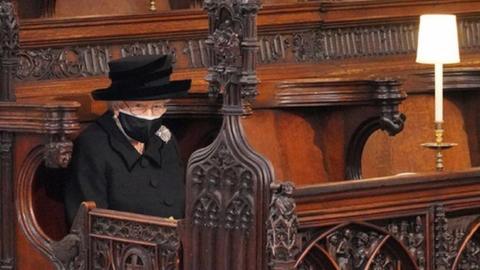 Queen Elizabeth II takes her seat for the funeral of Britain's Prince Philip, who died at the age of 99, at St George's Chapel, in Windsor.