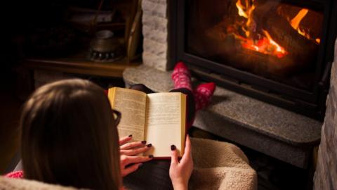 Woman reading in front of stove