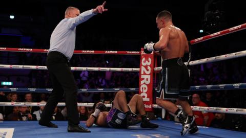 Nick Ball is pointed away by the referee with Ronny Rios on the canvas