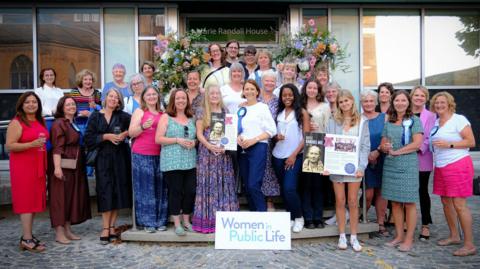 A group of women standing outside Marie Randall House