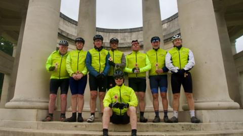 Team of cyclists at war memorial