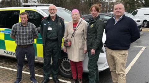 Sue Yarnell (centre) meeting paramedics who saved her life next to a Secamb ambulance