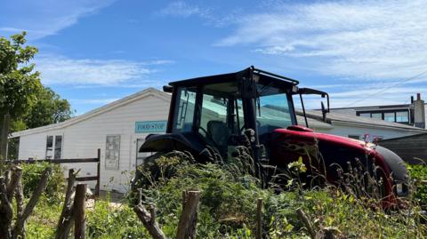 Tractor outside Food Stop on the avenue