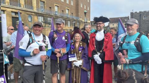 Three men are greeted at the finish line in Norwich