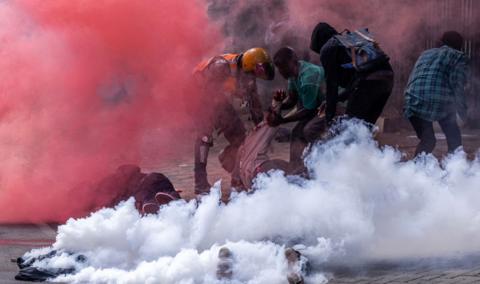 Protesters try to help injured people outside the Kenya Parliament during a nationwide strike to protest against tax hikes and the Finance Bill 2024 in downtown Nairobi, on June 25, 2024