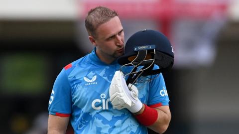 Livingstone kisses the badge on his helmet after reaching three figures