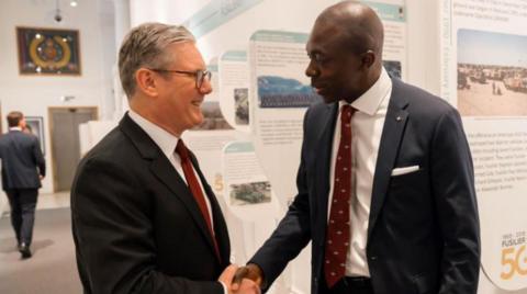 Bayo Alaba shaking hands with Sir Kier Starmer indoors