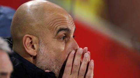 Pep Guardiola with his hands partially covering his face