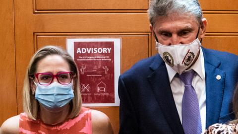 Sen. Kyrsten Sinema and Sen. Joe Manchin board an elevator on Capitol Hill on 30 Sept 2021 in Washington, DC