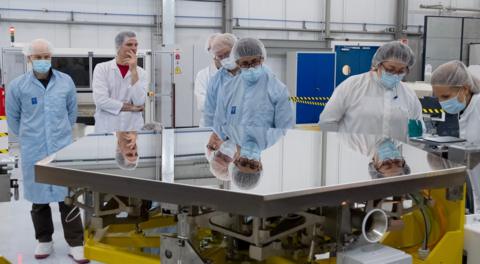 Engineers stand around one of the Extremely Large Telescope (ELT)’s primary mirror segments