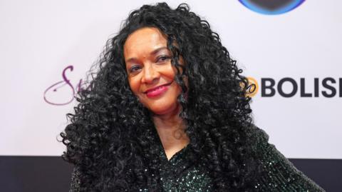 Kanya King at the 2024 MOBO Awards. She wears a dark sequined dress and smiles at the camera, tilting her head slightly to the left. 