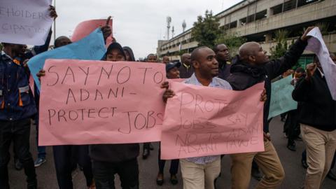 Members of the Kenya Aviation Workers Union (KAWU) picket outside Jomo Kenyatta International Airport (JKIA) over plans to sell the airport to Adani Airport Holdings Ltd, in Nairobi, Kenya, on Monday, Sept. 2, 2024. They are holding posters which read: Say No to Adani - protect jobs