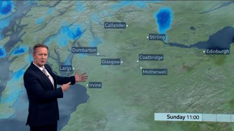 BBC weather presenter Christopher Blanchett in front of weather map showing rain showers