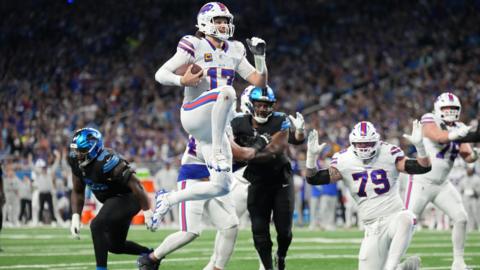 Buffalo Bills quarterback jumps into the end zone to score a touchdown against the Detroit Lions