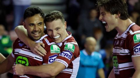 Wigan's Bevan French (left) gets a hug after scoring a try against Leigh