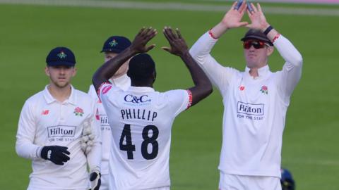 Skipper Keaton Jennings congratulates Anderson Phillip after taking a wicket