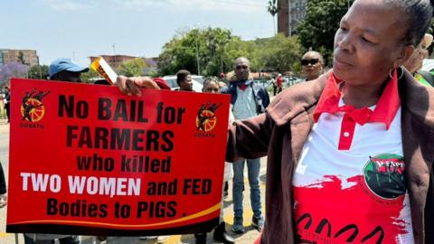 A protester outside the court in Polokwane, holding a placard saying: "No bail for farmers who killed two women and fed bodies to pigs" - Wednesday 2 October 2024