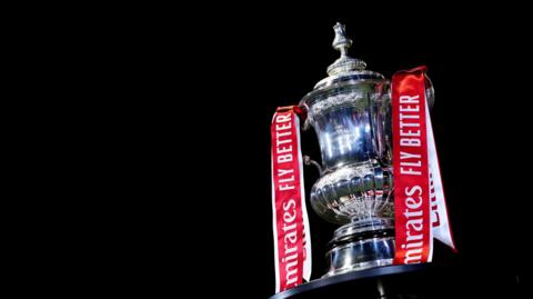 Photo of trophy with red and white ribbons saying Emirates fly better