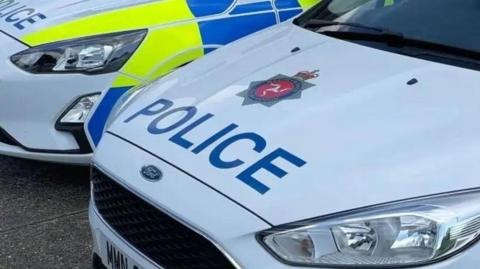 A white police car with the word police on the bonnet alongside the Isle of Man Constabulary crest above it.