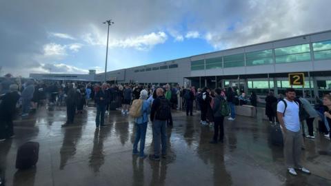 People standing on the tarmac at Bristol Airport. 