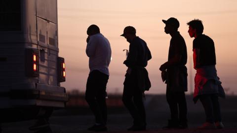 Migrants waiting to board bus in Arizona after crossing from Mexico