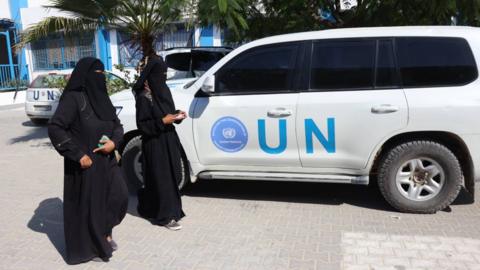 Palestinian women walk past a UN vehicle at the Unrwa Japanese Health Center in Khan Yunis on the southern Gaza Strip on 29 October 2024