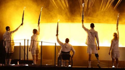 A picture of Para-athletes lighting the Paralympic torch