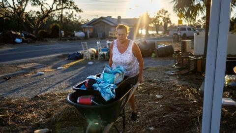 Melinda Segassie wheels some items salvaged from her home in Steinhatchee, Florida