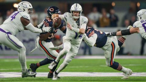 Sam Darnold scrambles to avoid the pressure of defensive end DeMarcus Walker