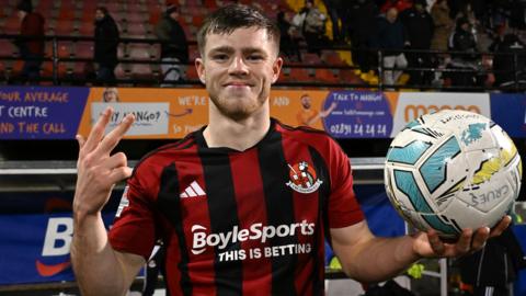 Kieran Offord celebrates with the match ball after helping Crusaders beat Dungannon Swifts 4-2 after extra-time