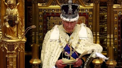 Britain's King Charles III, wearing the Imperial State Crown and the Robe of State, reads the King's Speech