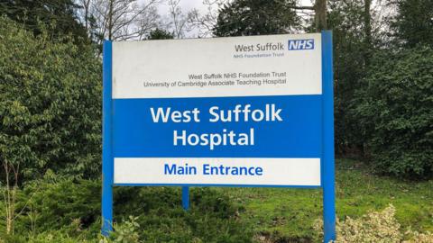 A blue and white sign which reads West Suffolk Hospital 