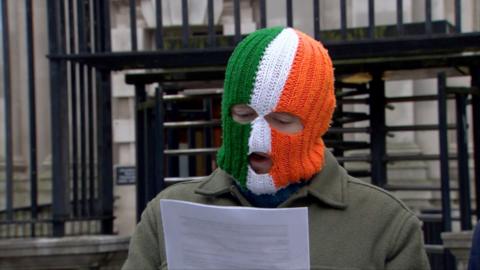 DJ Próvaí wearing a green, white and orange balaclava