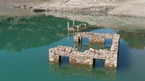 Ruins of stone building poke out the top of a lake