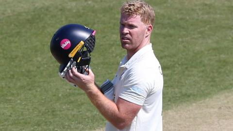 Ben Compton holding a cricket helmet