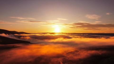 Sun shining above thick cloud 