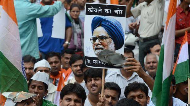 An activist from India Against Corruption (IAC) stamps the picture of Manmohan Singh before marching towards the Prime Minister's residence in Delhi on August 26, 2012