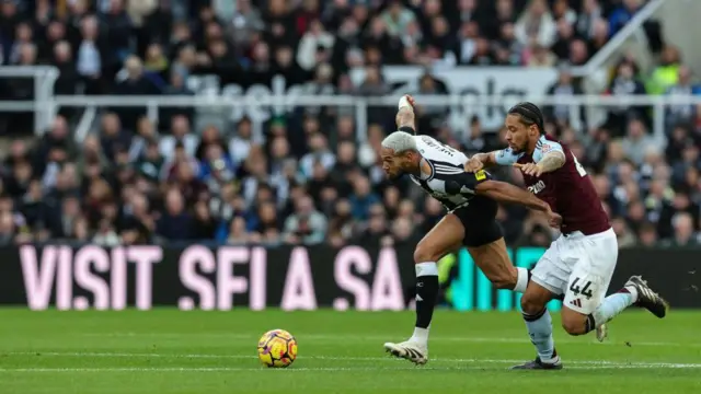 Joelinton of Newcastle United FC (7) is pulled back by Boubacar Kamara of Aston Villa