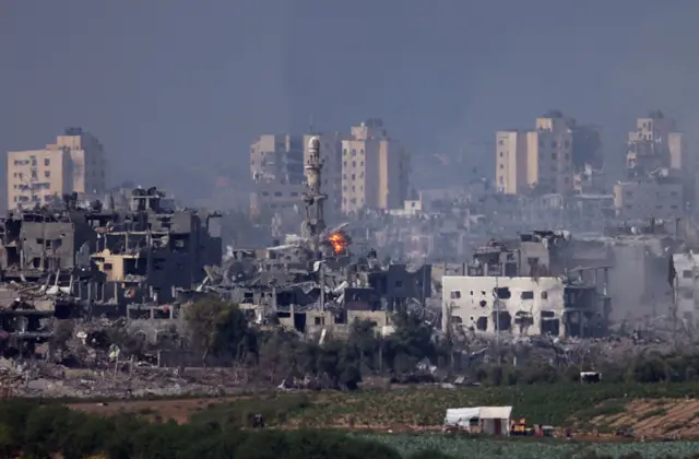 A missile strikes behind a minaret in Gaza on October 28, 2023