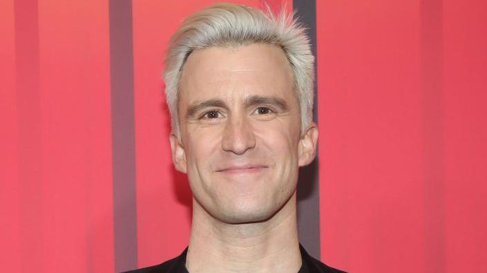 Gavin Creel head shot - he has bleach blonde short hair and brown eyes