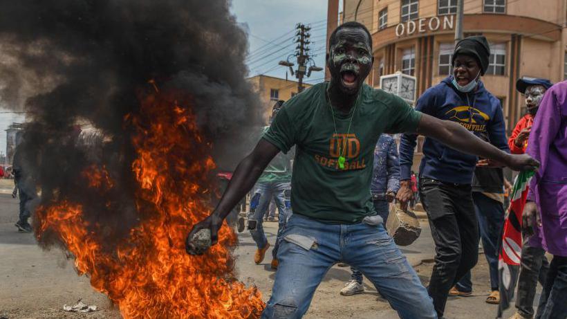 Demonstrators, gathering in the city center, make a fire as they march towards the parliament building to protest the 'Finance Bill 2024'