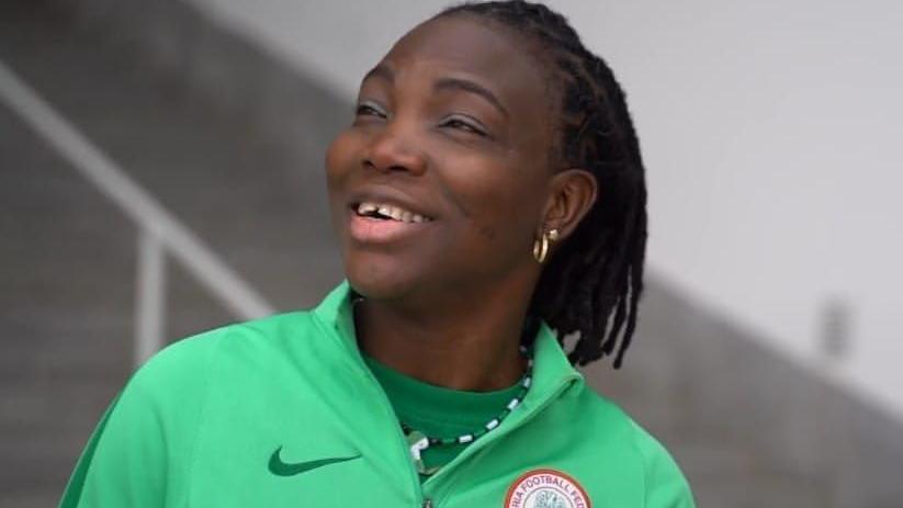 Ayisat Yusuf, wearing a green Nigeria tracksuit, smiles as she looks to her right