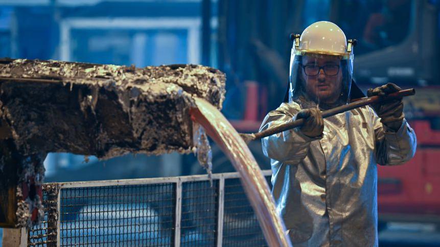 Wearing a protective silver suit a worker collects molten aluminium samples at a aluminium recycling and production plant, in eastern France. 