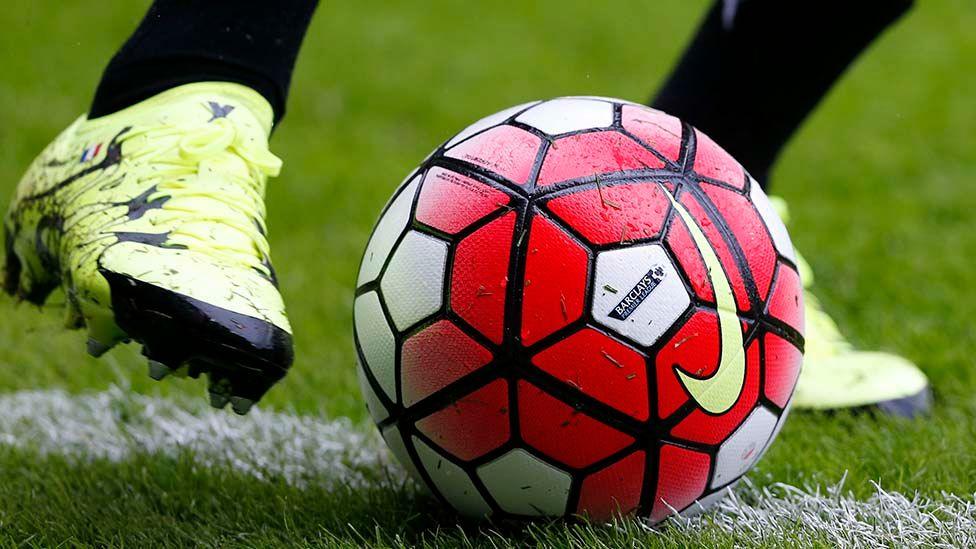 Close-up of a football about to be kicked on a pitch