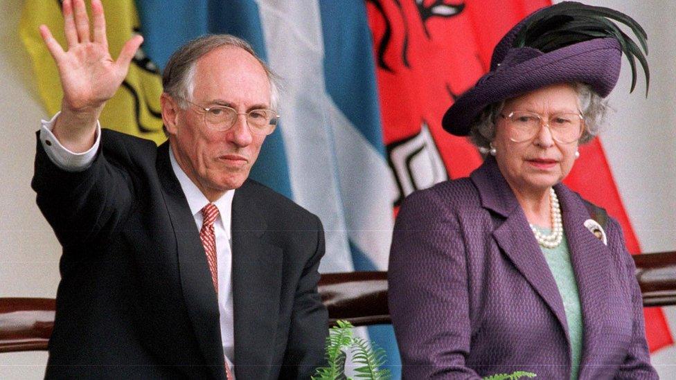 Scotland's first First Minister Donald Dewar watch the parades from the Royal Dias with the Queen after the opening of the Scottish Parliament in Edinburgh in July 1999