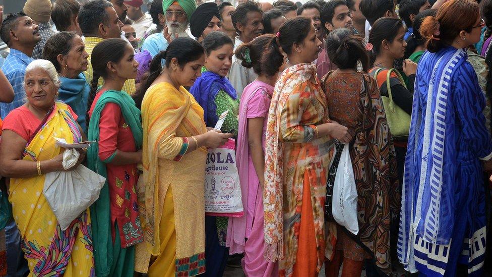 Indian bank customers wait to deposit 500 and 1,000 rupee notes at a bank in Amritsar on November 10, 2016.