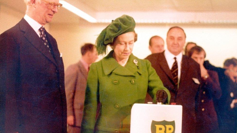 Queen Elizabeth II, presses a button to start the flow of oil from the North Sea's Forties Field into a refinery at Grangemouth, Scotland, Nov. 3, 1975.